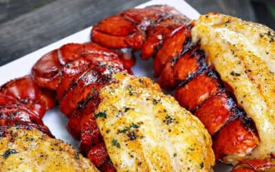 Grilled lobster tails with lemon butter sauce on a serving platter.