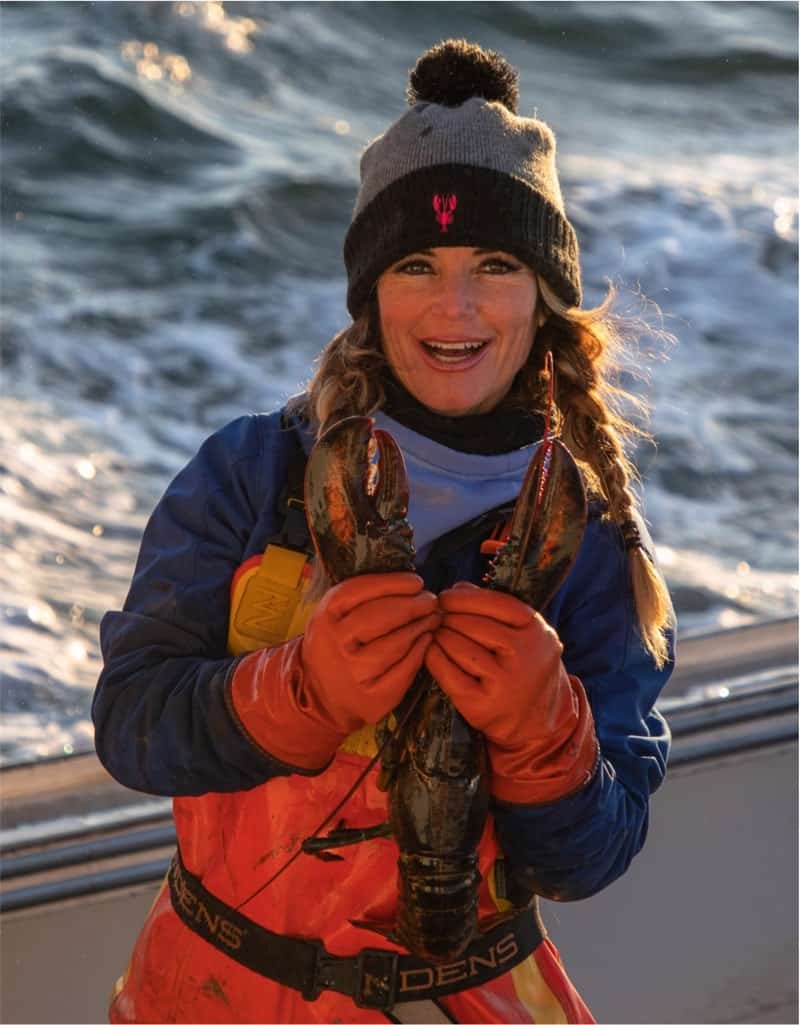 Lobster woman catches a fresh Maine lobster.